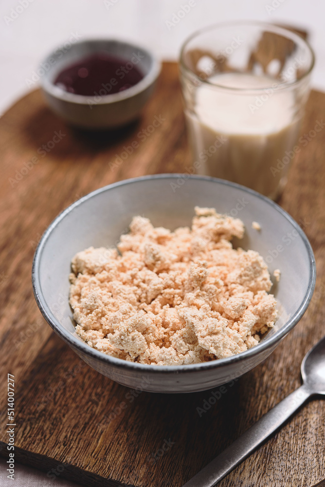 Homemade melted cheese curd served with baked milk and jam on wooden cutboard. Healthy breakfast. Haze effect. Selective focus Homemade melted cheese curd served with baked milk and jam on wooden cutboard. Healthy breakfast. Haze effect. Selective focus