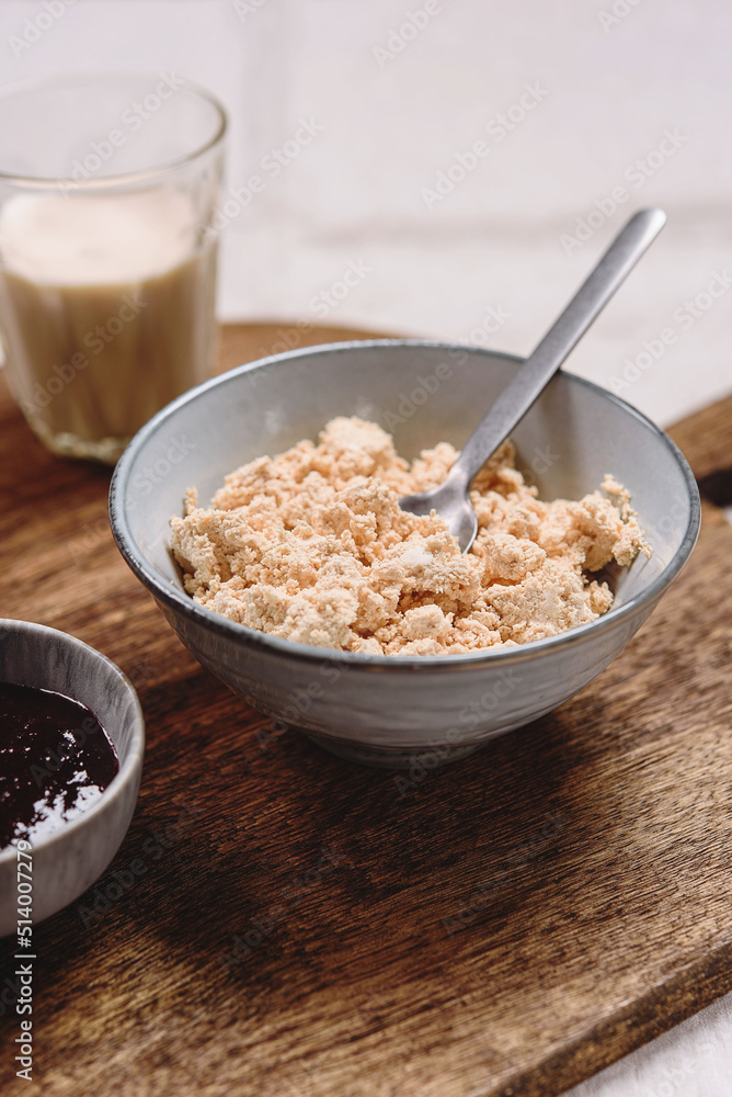 Homemade melted cheese curd served with baked milk and jam on wooden cutboard. Healthy breakfast. Haze effect. Selective focus Homemade melted cheese curd served with baked milk and jam on wooden cutboard. Healthy breakfast. Haze effect. Selective focus