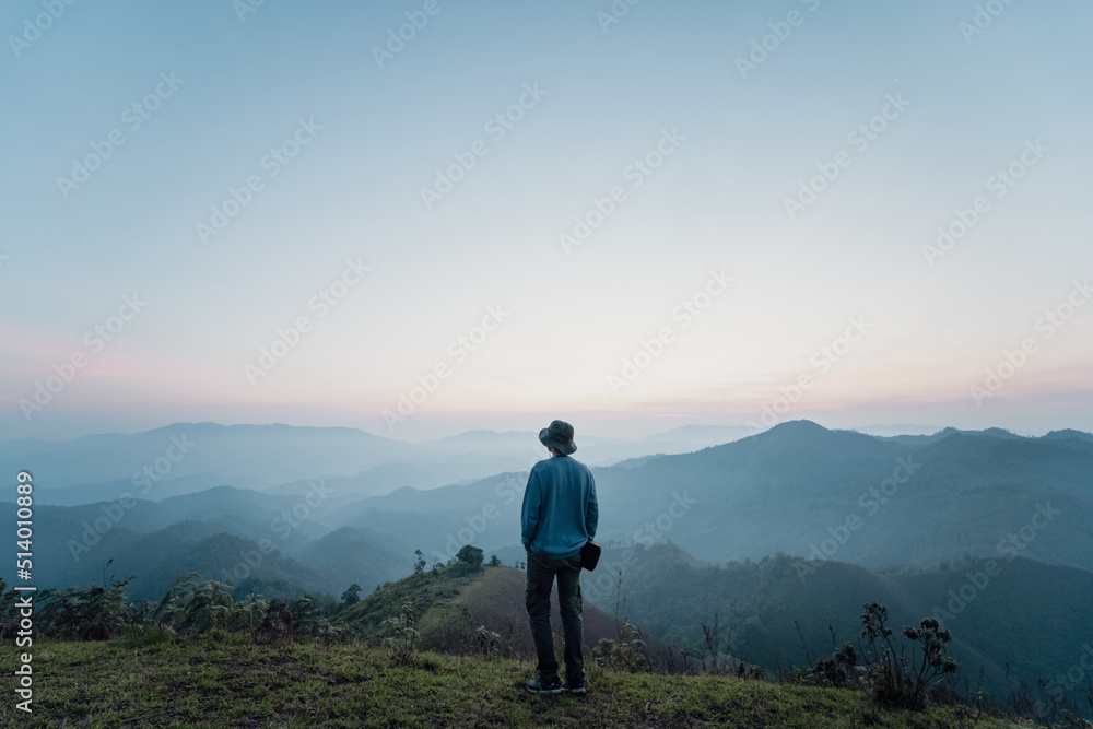 hiker man relax with wellbeing and happy feeling on top of mountain