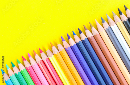 colored pencils with copy space on yellow background educational concept