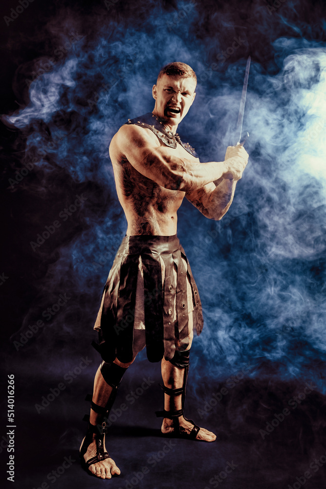 Antique warrior with sword against dark background with smoke