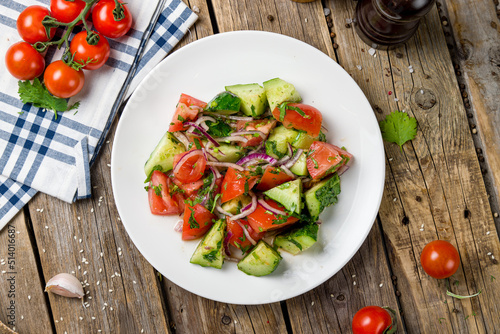 Vegetable salad with tomatoes and cucumbers top view on wooden table