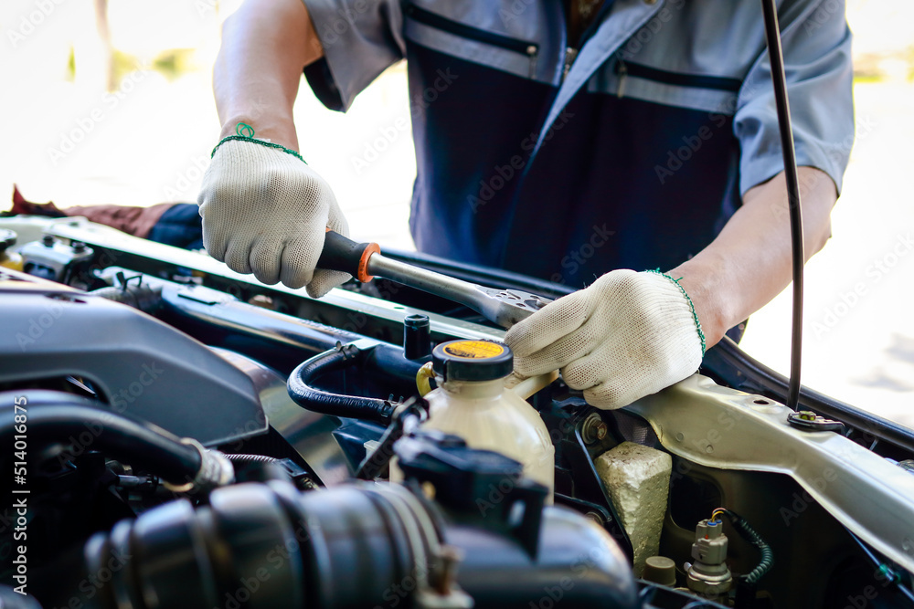 Auto mechanic is using wrench to repair and maintain engine. to customers who come to use the service. Concept of car care inspection and insurance. car garage Auto mechanic is using wrench to repair and maintain engine. to customers who come to use the service. Concept of car care inspection and insurance. car garage