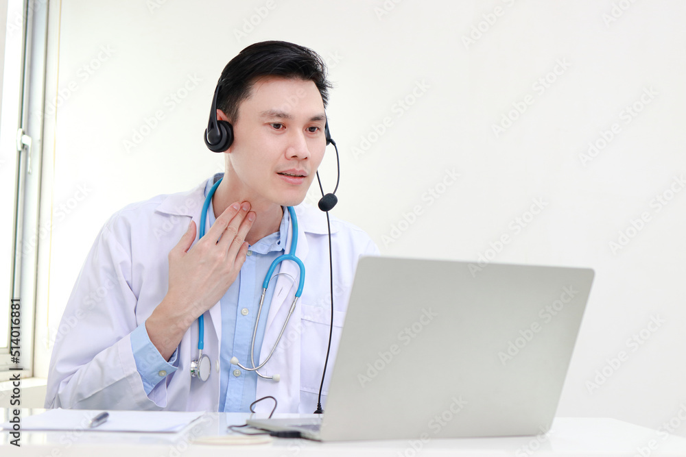 Asian male doctor treating patients online Talk via video call on laptop computer. Online treatment concept. Hospital medical services Asian male doctor treating patients online Talk via video call on laptop computer. Online treatment concept. Hospital medical services