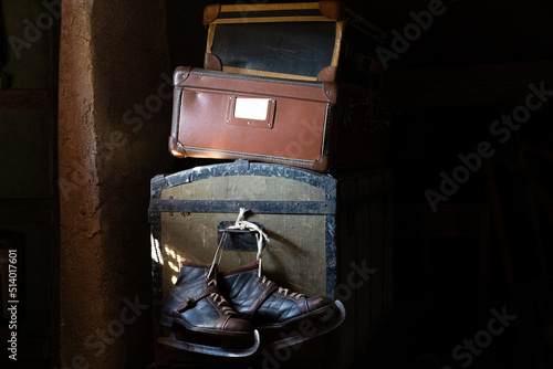 Stll life of antique cases and skates in attic, low key photo