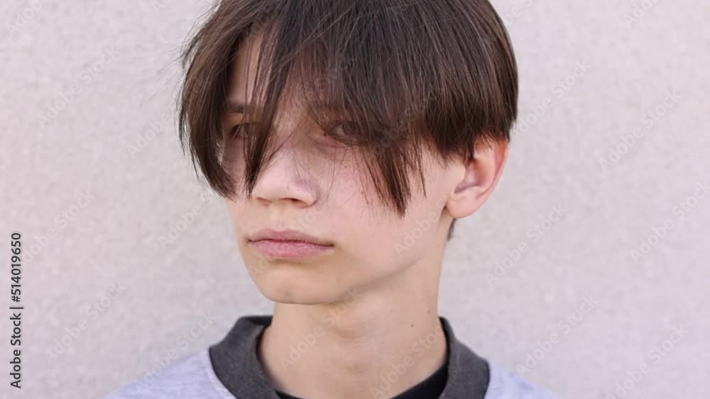 Young positive guy shaking his hair. Handsome teen boy shakes his head on wall background. Lifestyle concept. Slow motion. Young positive guy shaking his hair. Handsome teen boy shakes his head on wall background. Lifestyle concept. Slow motion.