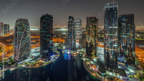 Tall residential buildings at JLT aerial night timelapse  part of the Dubai multi commodities centre mixed-use district.