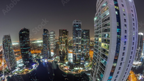 Panorama of tall residential buildings at JLT aerial night timelapse, part of the Dubai multi commodities centre mixed-use district.