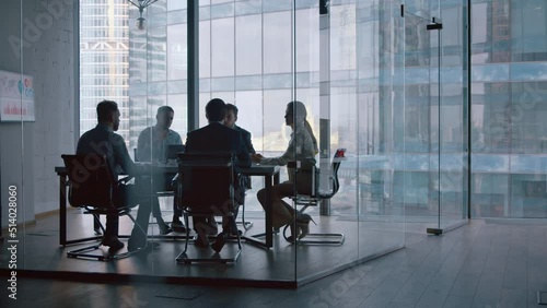 Business partners shaking hands after a completed deal in boardroom
