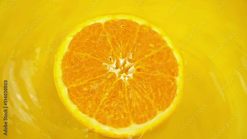 Rotating segments of a ripe and juicy orange on an orange background. Slow motion. Rotating segments of a ripe and juicy orange on an orange background. Slow motion.