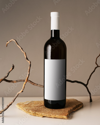 Blank white label mock up on black bottle of unlabeled wine on a table. Alcohol bottle mockup presentation ready for logo design. Full drink bottle template with empty sticker.