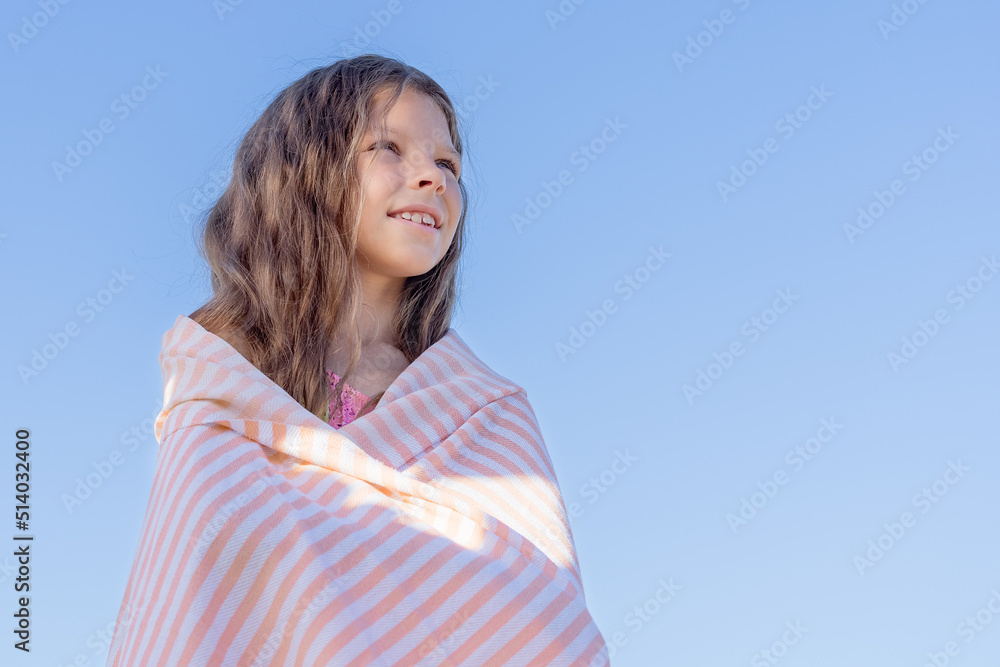 Portrait of a girl wrapped in a towel against the blue sky. Portrait of a girl wrapped in a towel against the blue sky.