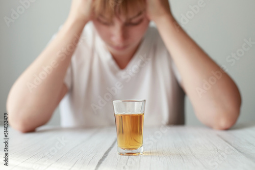 woman holding her head against the background of strong alcohol