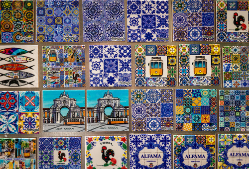 Numerous souvenir magnets from the city of Lisbon, Portugal.