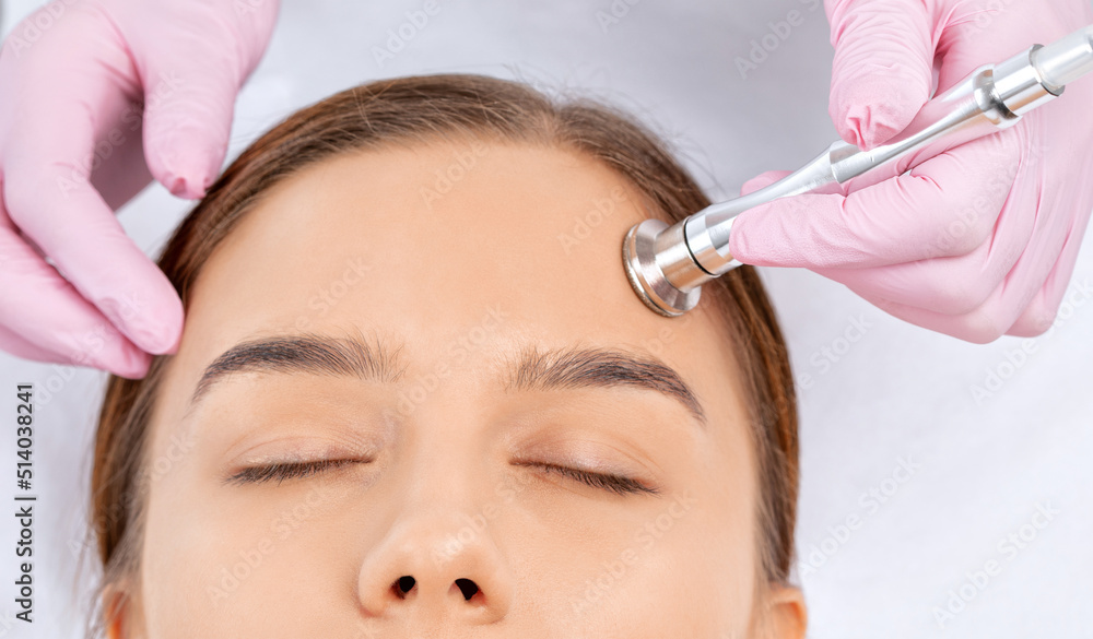Procedure microdermabrasion on the face against acne and blackheads. Women's cosmetology in the beauty salon. Procedure microdermabrasion on the face against acne and blackheads. Women's cosmetology in the beauty salon.