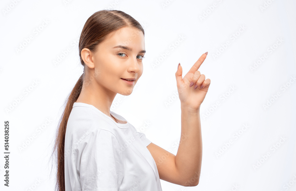 Beautiful young woman with clean skin and a beautiful smile in a white t-shirt shows something. Makeup and healthy clear skin.