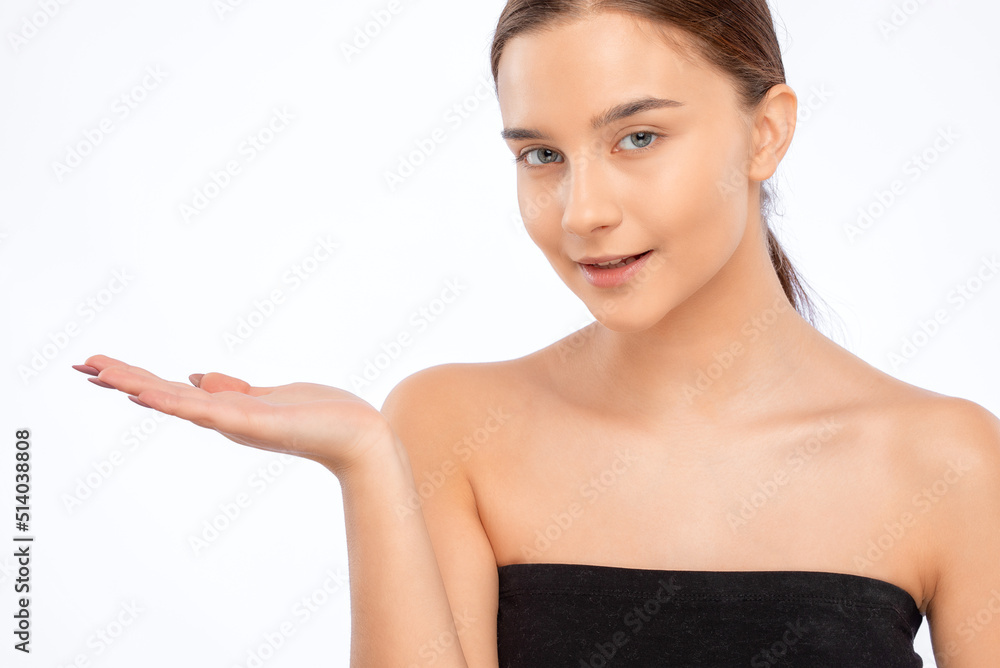 Beautiful young woman with clean skin and a beautiful smile shows something. Makeup and healthy clear skin. Beautiful young woman with clean skin and a beautiful smile shows something. Makeup and healthy clear skin.
