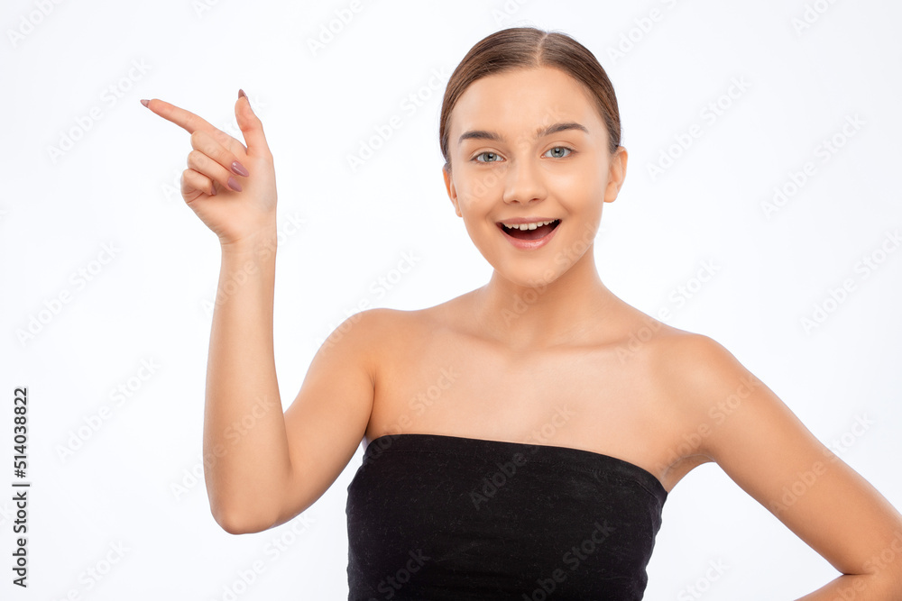 Beautiful young woman with clean skin and a beautiful smile shows something. Makeup and healthy clear skin. Beautiful young woman with clean skin and a beautiful smile shows something. Makeup and healthy clear skin.