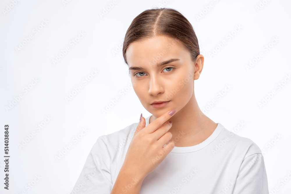 Beautiful young pensive woman with clean skin in a white t-shirt. Makeup and healthy clear skin. Beautiful young pensive woman with clean skin in a white t-shirt. Makeup and healthy clear skin.