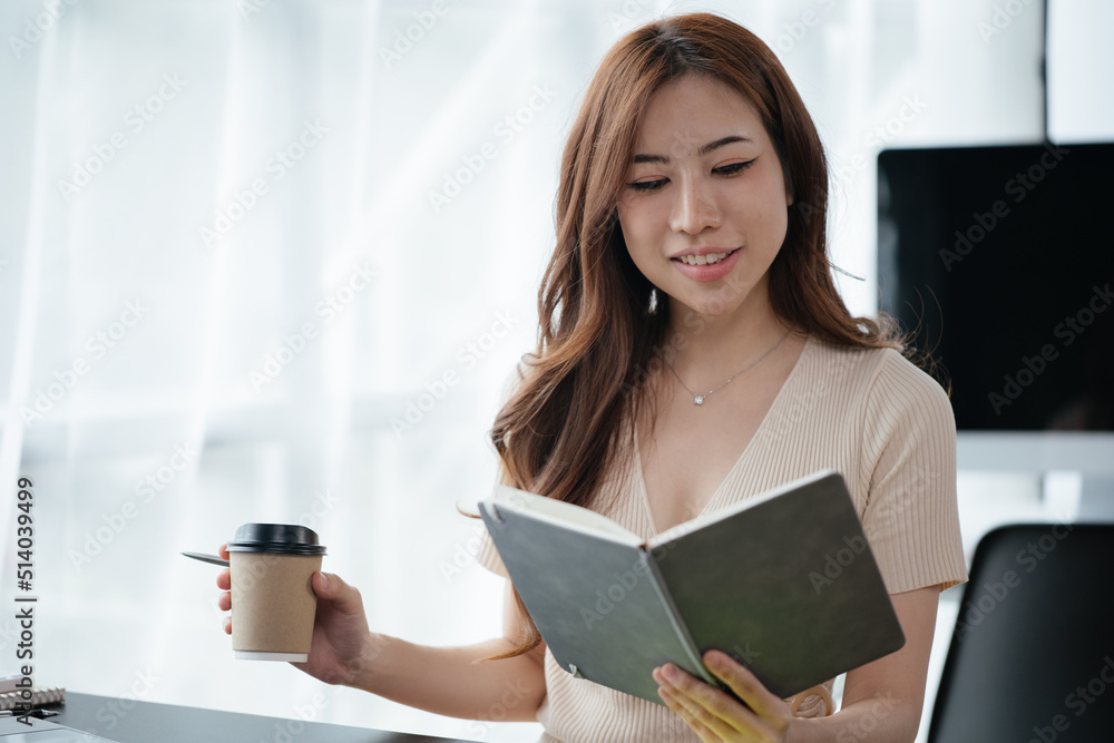 Businesswoman is holding and drinking a cup of coffee in office space Businesswoman is holding and drinking a cup of coffee in office space