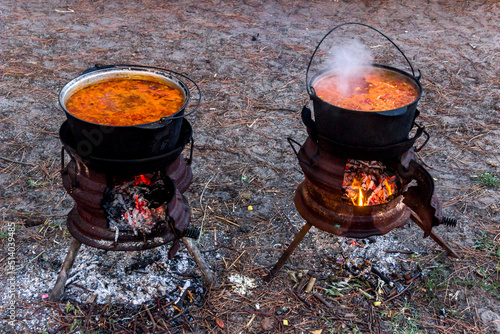 two cauldrons with red borsch on fire