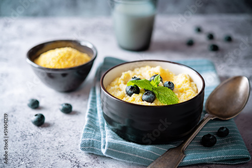 Corn porridge with fresh blueberries in a bowl photo