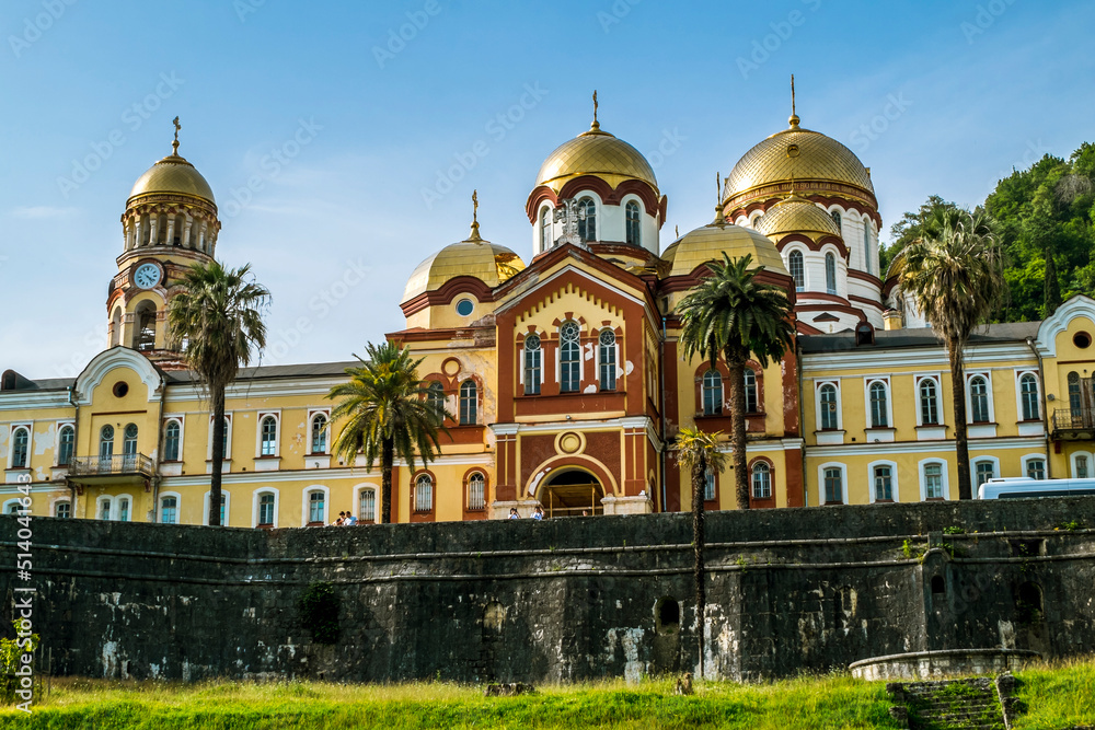 New Athos monastery with bright golden domes at sunny summer day among green trees