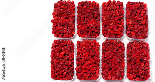 Ripe red fragrant raspberries collected in a farm in a transparent container for sale.