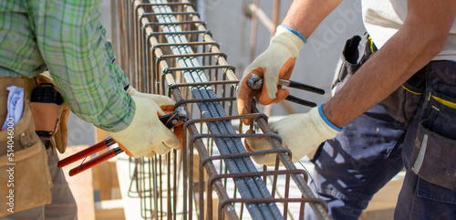 Canvastavla bricklayers with yellow helmet and protective glasses building an iron beam for