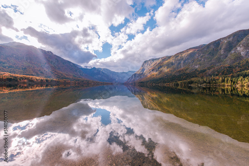 Autumn landscape by the lake Bohinj in Julian Alps. Fascinating reflectins in the lake on a cloudy day. photo