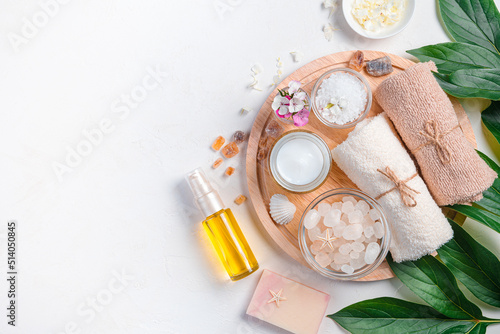 Spa composition with oil, cream and spa accessories on a light background. Top view, copy space.