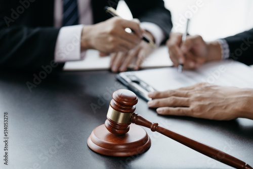 Small hammer gavel on the desk in the lawyer's room, using the law to judge with fairness and justice, defending the lawyer's case against the client. Concept of law and justice.