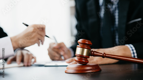 Fotografia Small hammer gavel on the desk in the lawyer's room, using the law to judge with fairness and justice, defending the lawyer's case against the client
