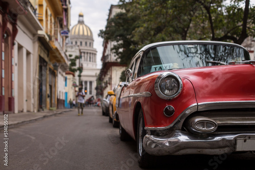 Old car on streets of Havana with colourful buildings in background. Cuba © danmir12