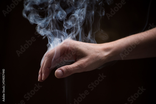  hand down with smoke between the fingers, harmony concept © Jezabel