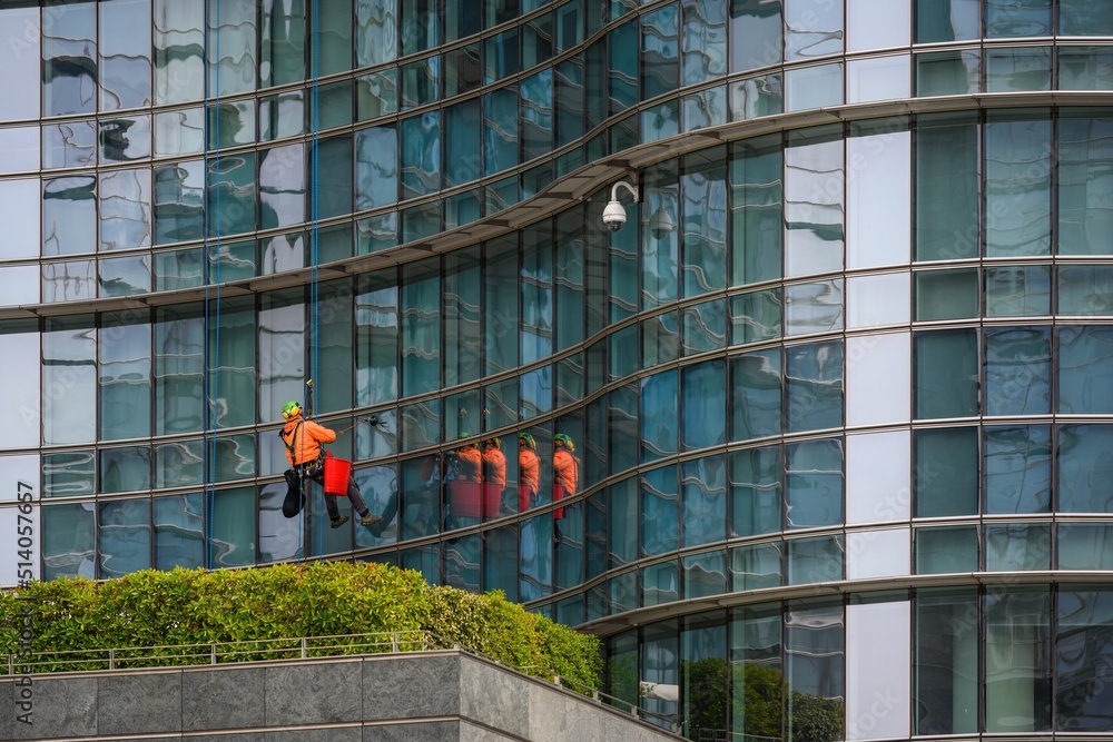 Worker cleaning windows service on high rise building