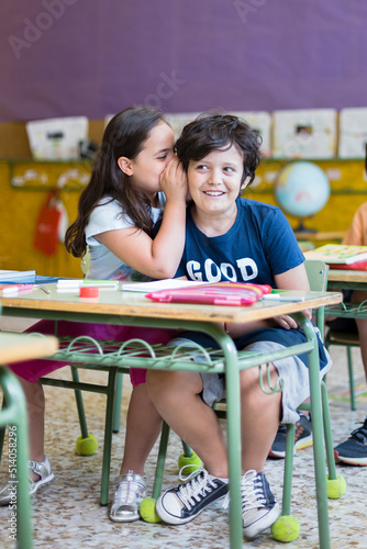 Two funny caucasian toddlers talking distractedly in class. Primary education. Back to school concept.  photo