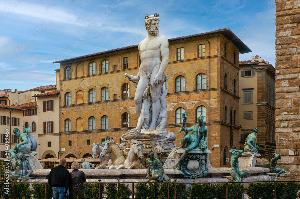 Fountain of Neptune, Firenze with people watching in front of it on a sunny day. Fountain of Neptune under blue sky in Florence, Italy.