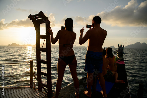 Dos personas observan la Puesta de sol El Nido en la isla de Pinagbuyutan, vistas naturales del paisaje kárstico, acantilados. Palawan, Philippines. Viajes de aventura. photo
