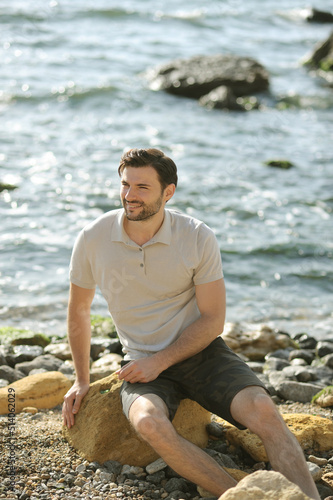 Young stylish man tourist have a rest outdoor near the sea
