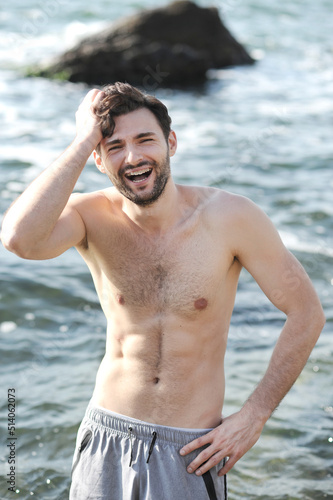 Young joyful man portrait near ocean  topless body