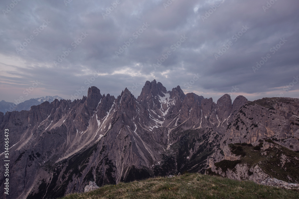 Mountains Panorama of the Dolomites at Sunrise with clouds. Photograph is showing Tre Cime di Lavaredo in the Dolomites, Italy. Beautiful morning, just before the sunrise with soft tones and colors.