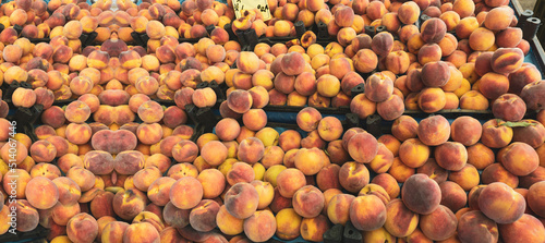 Orange peaches on the market bench or counter. Lots of Aegean or Mediterranean agricultural products background concept photo. High resolution.