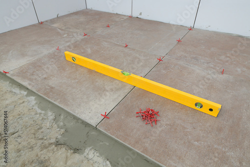 Level tool for measure of tiles position at floor, kitchen or bathroom renovation photo