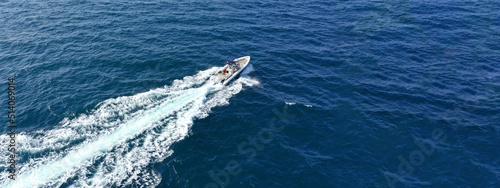 Aerial drone ultra wide photo with copy space of luxury rigid inflatable speed boat cruising in high speed in Aegean deep blue sea, Greece © aerial-drone