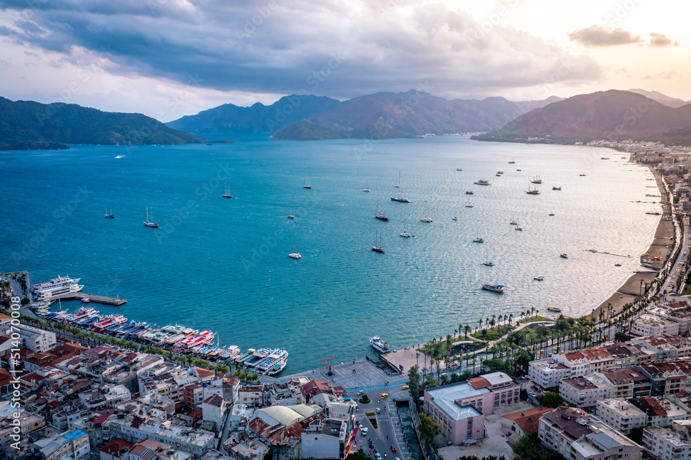Aerial view of Marmaris harbor with yacht and sailboat. Colorful landscape of evening Turkish city.
