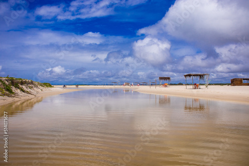 Praia deserta com maré baixa e com aguas cristalinas e palhoças   photo