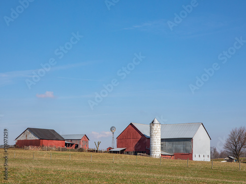 Amish red farm buildings on a hill with a silo and a windmill under a clear blue sky | Amish country, Ohio