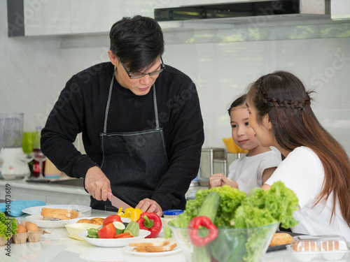 Family father mother son girl child happy holiday vacation cooking indoor house kitchen healthy vegetable salad gourmet delicious bakery enjoy fun smile eat lunch dinner time love together