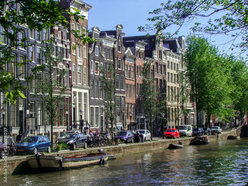 Canal in Amsterdan (Netherlands) a bridge and people in which we can see the arquitecture of amsterdam's house.